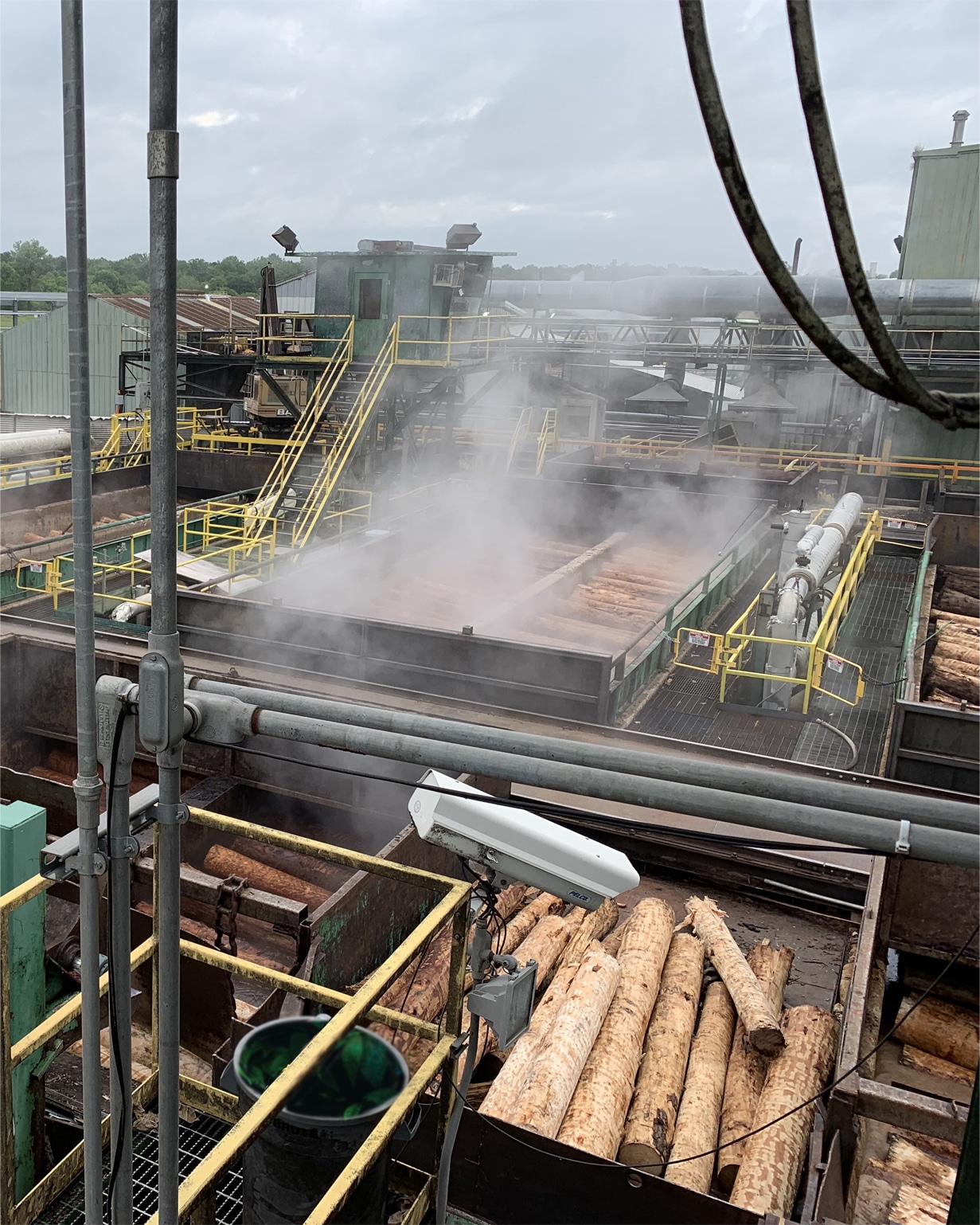 A photo of a lumber mill, with steam
